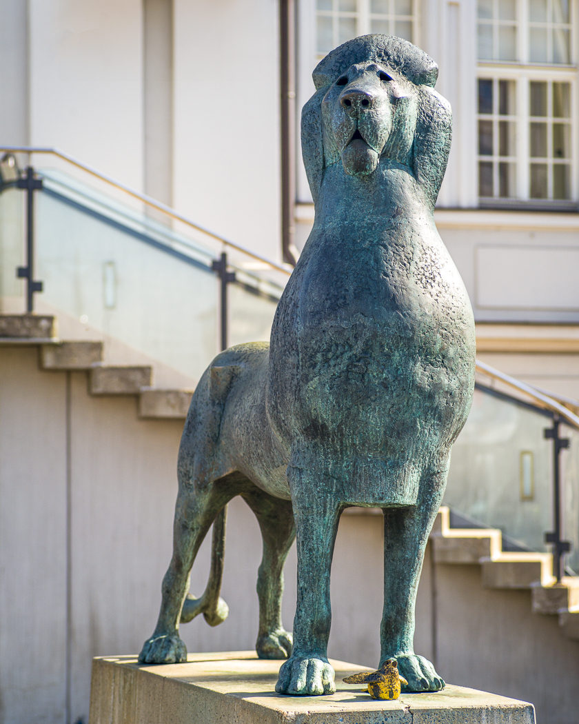 Bronzefigur mit Löwe und goldenem Spatz